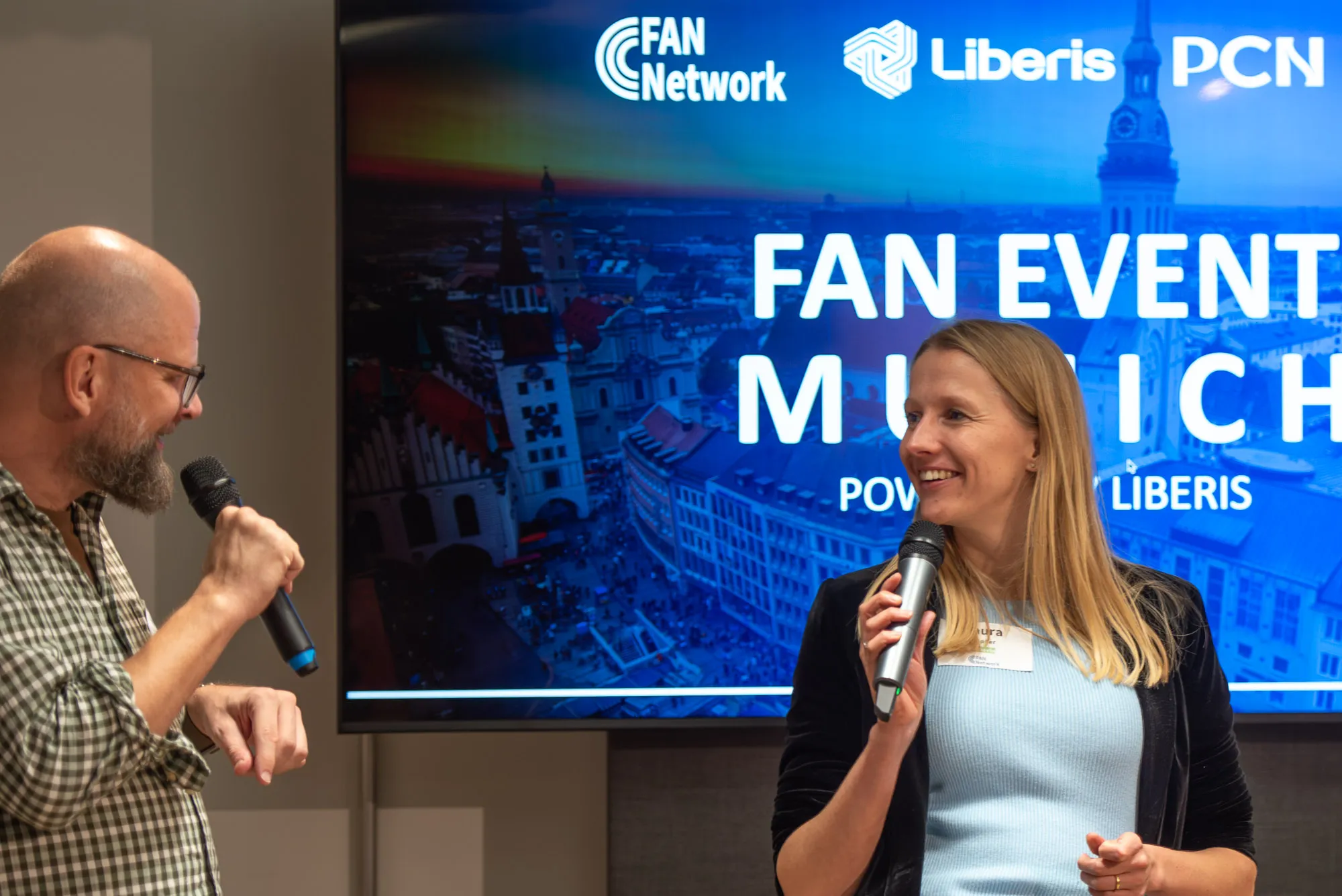 Speakers in front of the FAN Event Munich screen, powered by Liberis